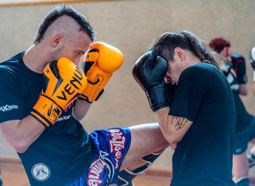 Ein Thaiboxer setzt sein Knie gegen einen anderen Thaiboxer sein